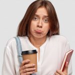 Girl Pouting with a Book and a Coffee